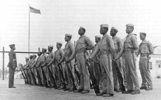 U.S. Marine Corps Cpl. Edgar R. Huff drilling a platoon of African American recruits at Camp Montford Point, 45 miles from the Cherry Point MCAS, in 1942. African Americans had served in the USMC since the Second World War and were fully integrated into Marine Corps units by the early 1950s. Photo by Capt. Aaron Moshier. Courtesy, National Archives U.S. Marine Corps Cpl. Edgar R. Huff drilling a platoon of African American recruits at Camp Montford Point, 45 miles from the Cherry Point MCAS, in 1942. African Americans had served in the USMC since the Second World War and were fully integrated into Marine Corps units by the early 1950s. Photo by Capt. Aaron Moshier. Courtesy, National Archives