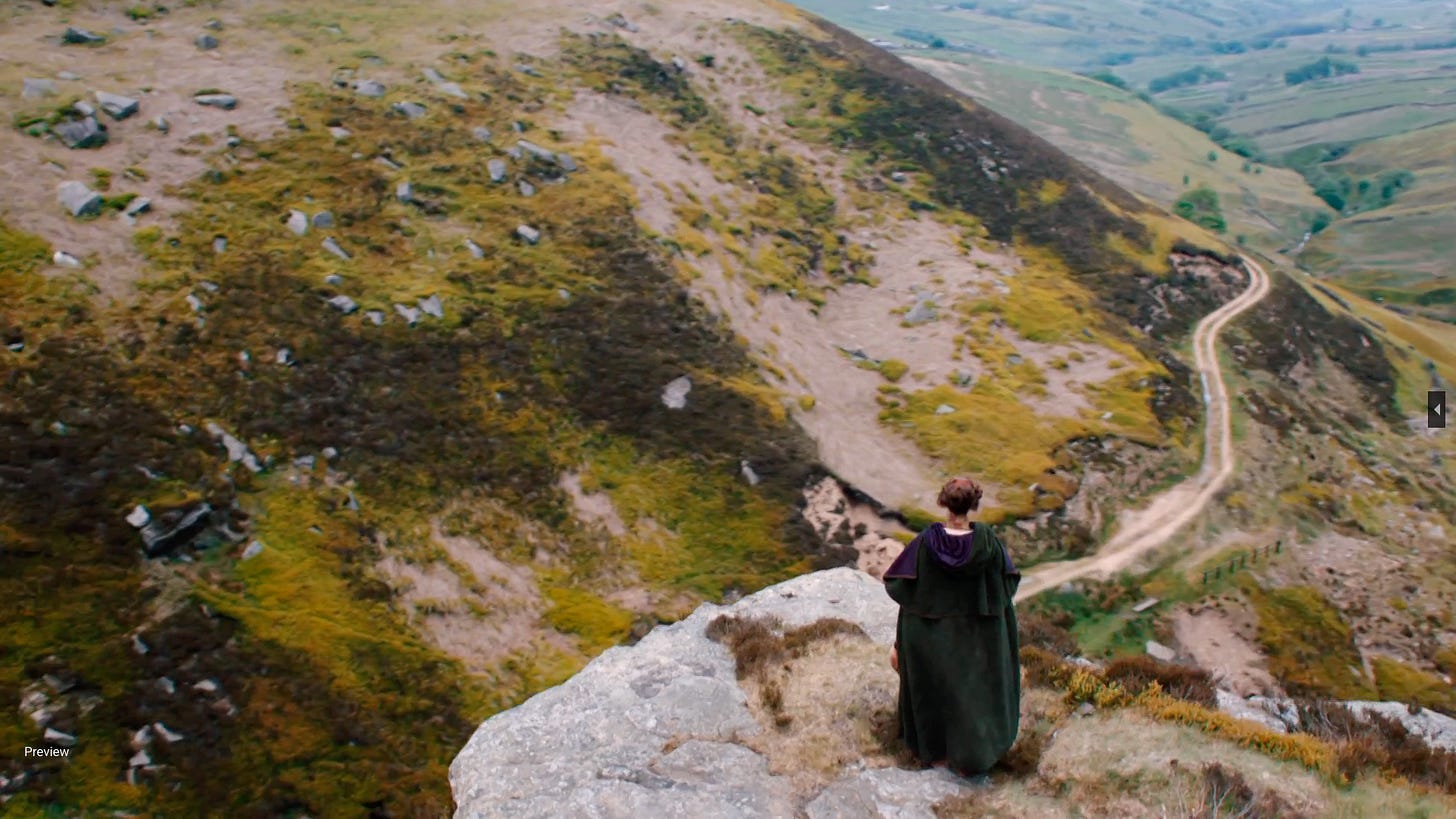 Woman in black cloak on rock at the top of Ponden Kirk Woman in black cloak on rock at the top of Ponden Kirk