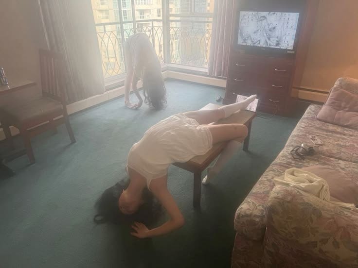 This may contain: a woman laying on the floor in front of a tv