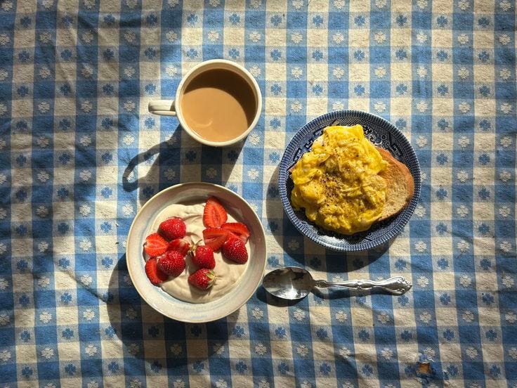 This may contain: two plates of food on a blue and white checkered tablecloth next to a cup of coffee