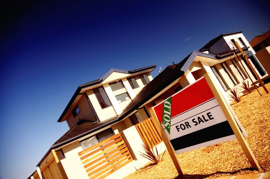 Photo of house, with For Sale - and SOLD sticker - sign outside front fence.