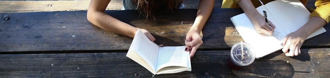 woman reading book while sitting on chair woman reading book while sitting on chair