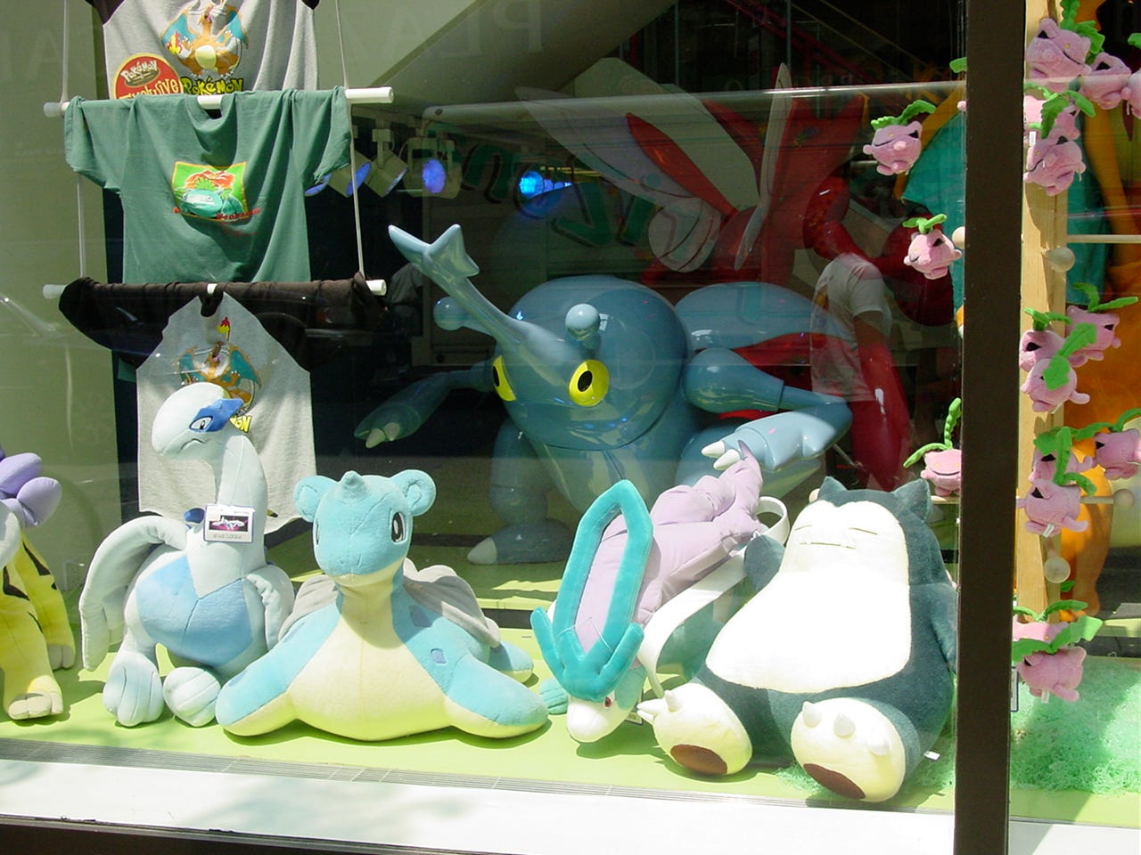 Another photograph of the window display taken from outside the store, showing a Heracross statue and various large plushies, including Lugia, Lapras, Suicune, Raikou, and Snorlax Another photograph of the window display taken from outside the store, showing a Heracross statue and various large plushies, including Lugia, Lapras, Suicune, Raikou, and Snorlax