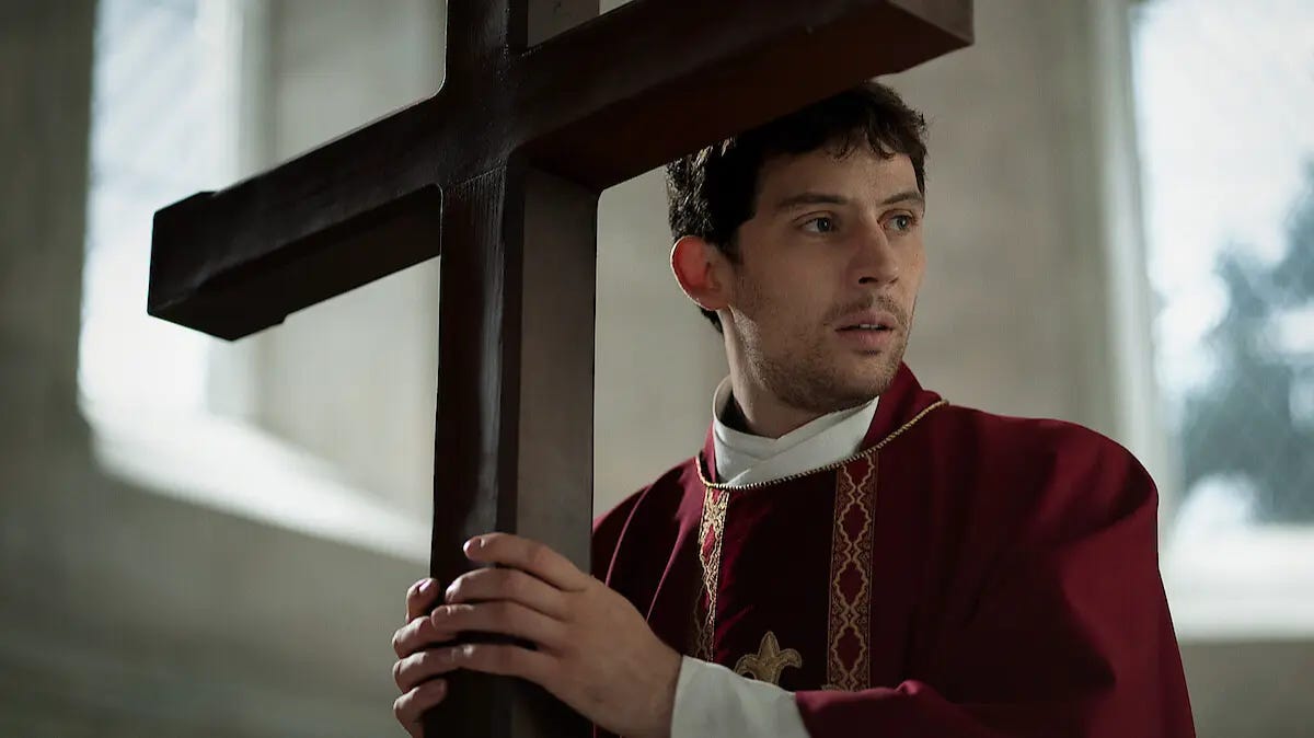 Josh O'Connor as Father Jud in Wake Up Dead Man angstily gripping a cross Josh O'Connor as Father Jud in Wake Up Dead Man angstily gripping a cross