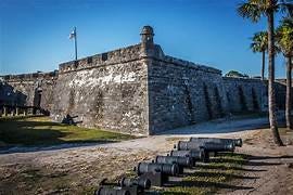 A stone wall with cannons in front of it

Description automatically generated