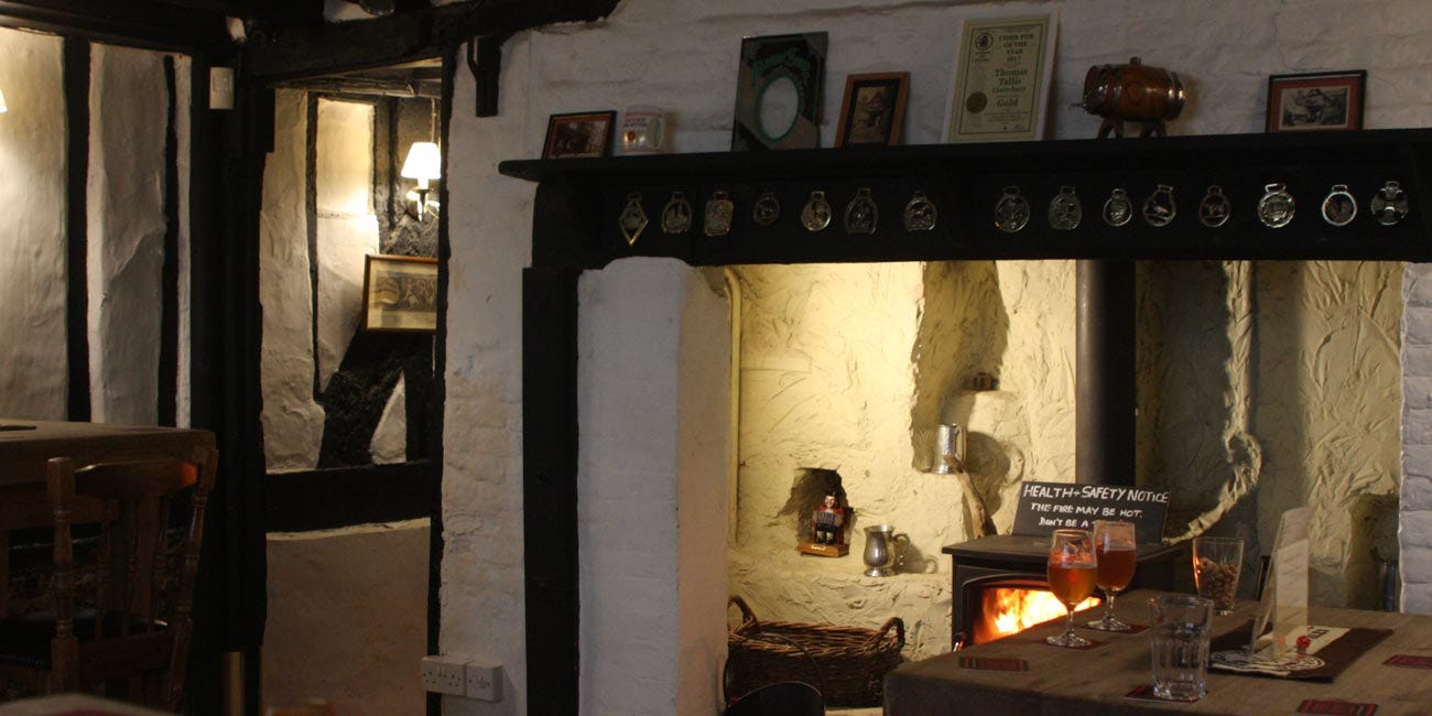 Fireplace with log burner, low beam ceilings, dingy lighting - hard to get a good photo in this place, I suppose!