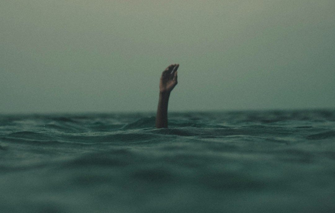 person with hand above water