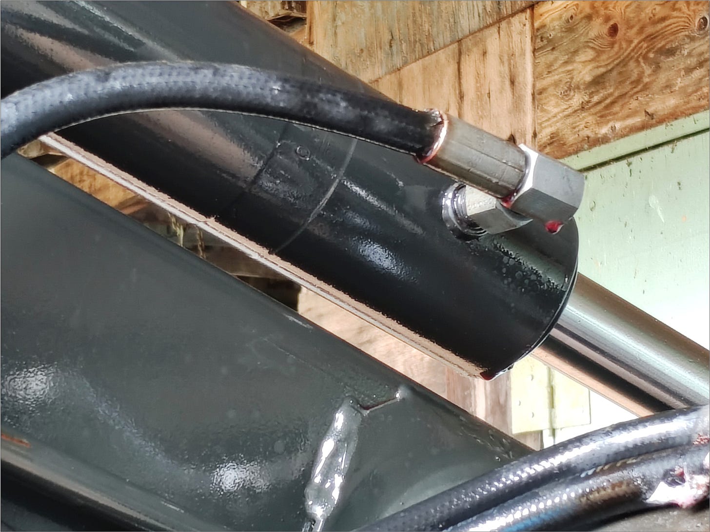 Broken hydraulic hose with bleeding red hydraulic fluid.