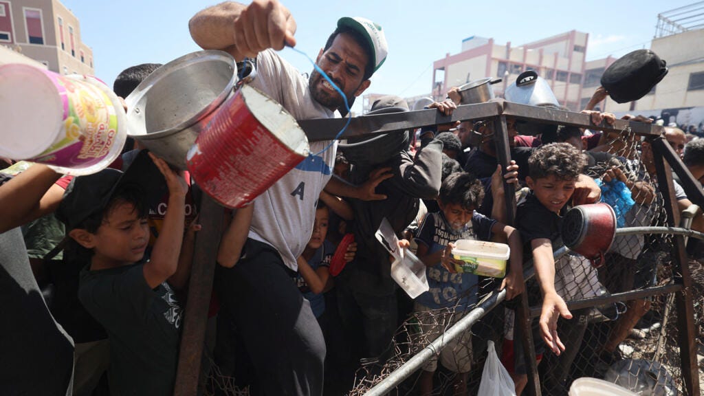 Palestinians gather at a food distribution point in the Nuseirat refugee camp in the central Gaza Strip on July 19, 2025. 