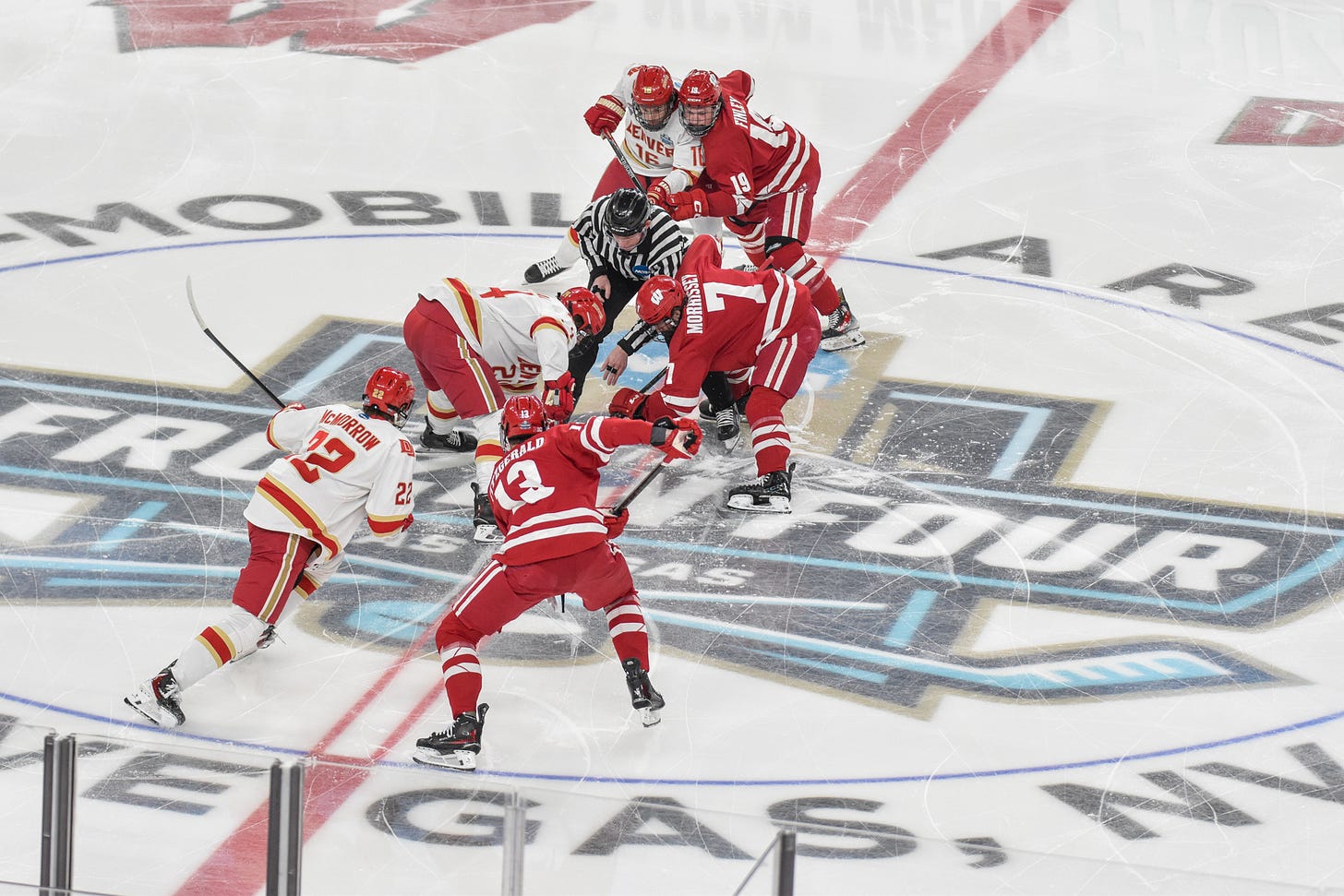 Gavin Morrissey, Christian Fitzgerald and Quinn Finley at center ice for opening faceoff on top of frozen four logo in Las Vegas, Nevada.