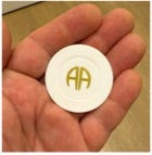 A hand holding a white chip

Description automatically generated