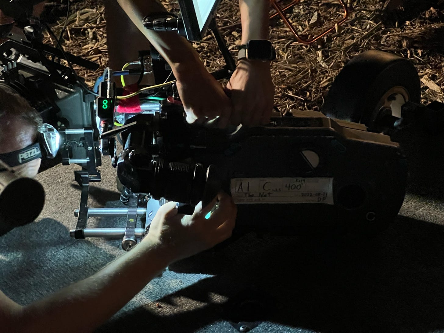 Two people work to check the gate on a motion picture camera loaded with 35mm film.