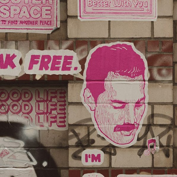 a bunch of pink stickers on a brick wall