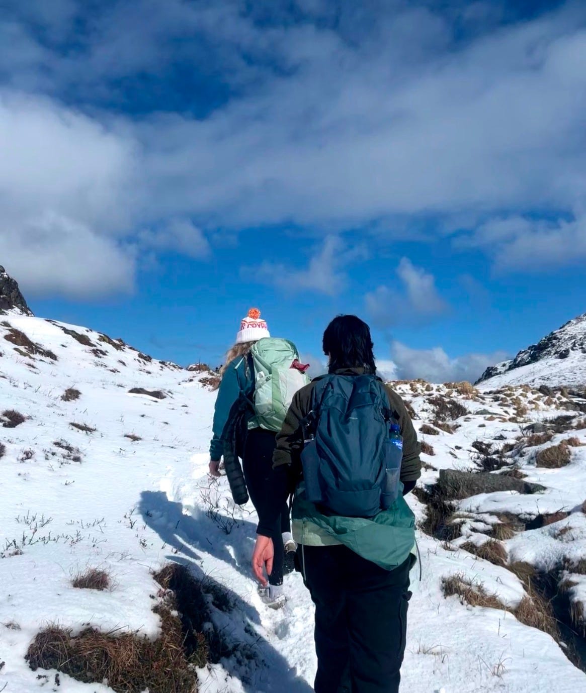 Two people walking up a mountain