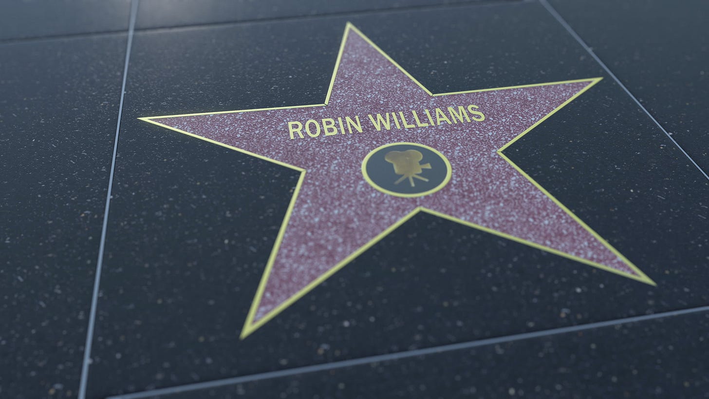 Robin Williams' star on the walk of fame - a purple star, outlined in gold on black tiles