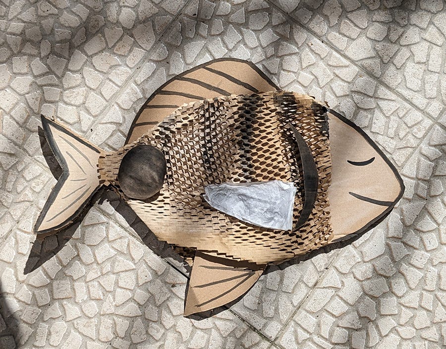 photo of a fish made out of cardboard scraps and black paint