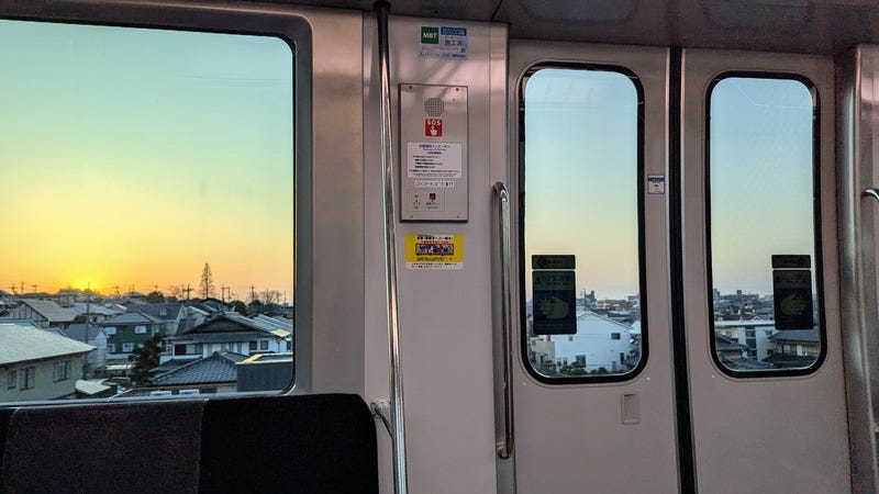 A view of houses out the window of a Japanese train