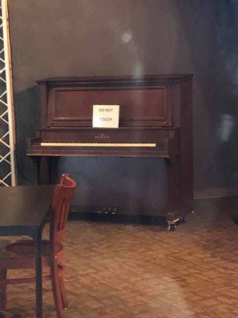 A piano with a sign on it that reads "Do Not Touch"