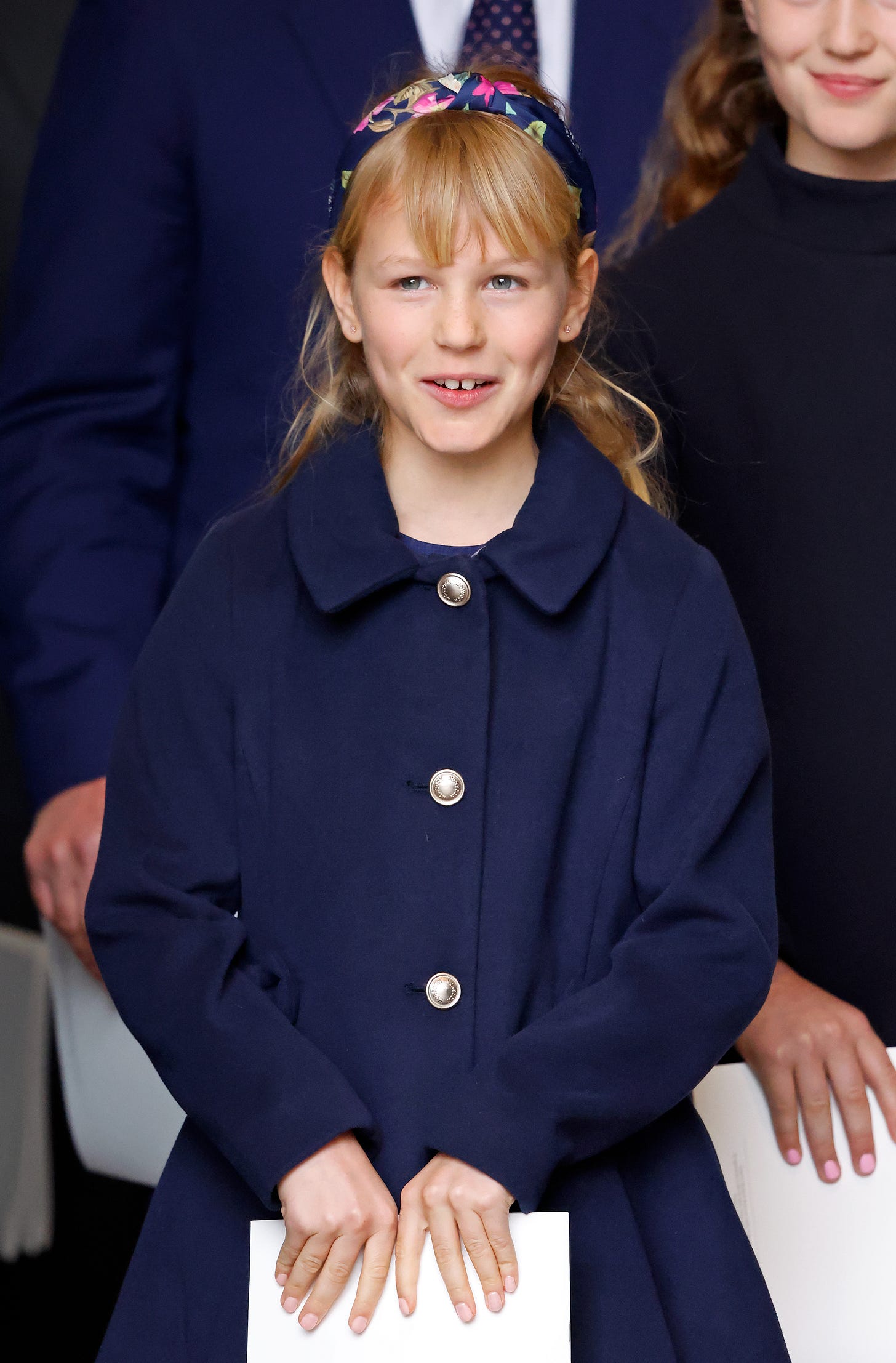 Isla Phillips wearing navy coat and floral headband