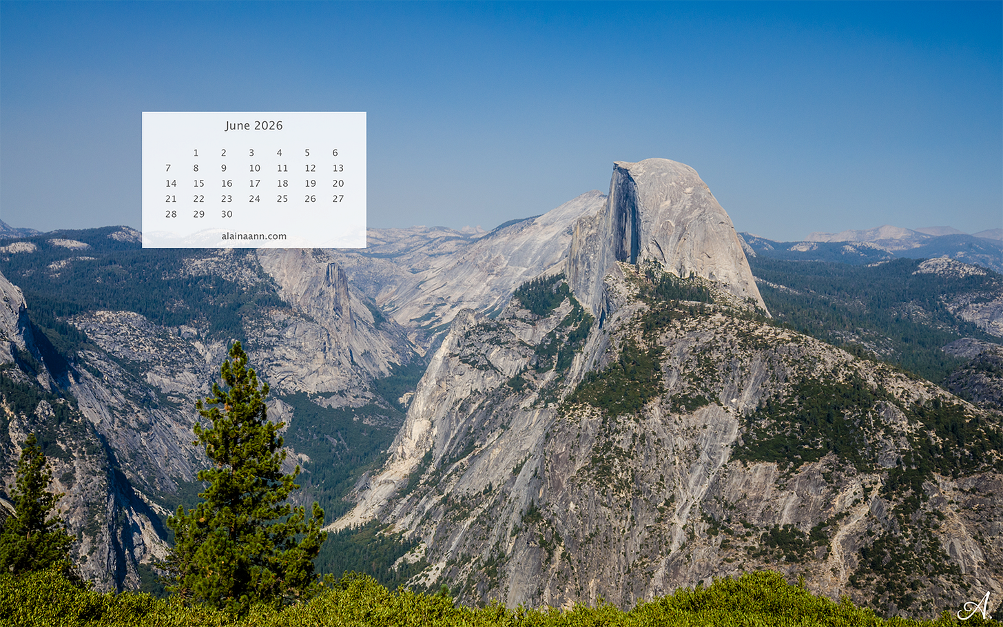 A June calendar overlaying a scenic mountain landscape.