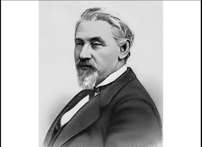 Black-and-white portrait of Joseph Seligman, a man with gray hair, mustache, and beard, wearing a formal suit, white shirt, and bow tie, posed against a plain background in a studio setting.