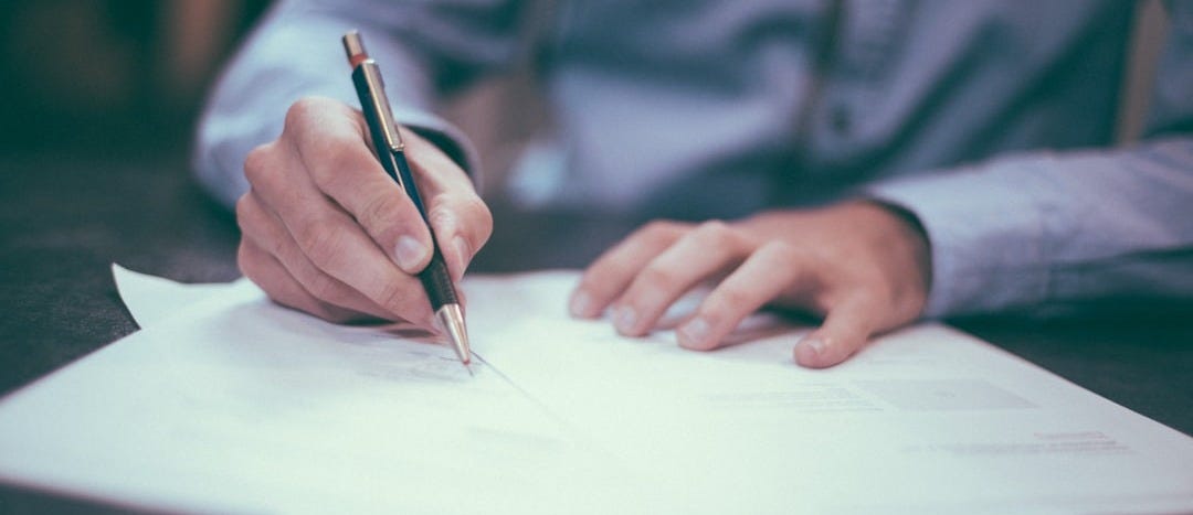 man writing on paper man writing on paper