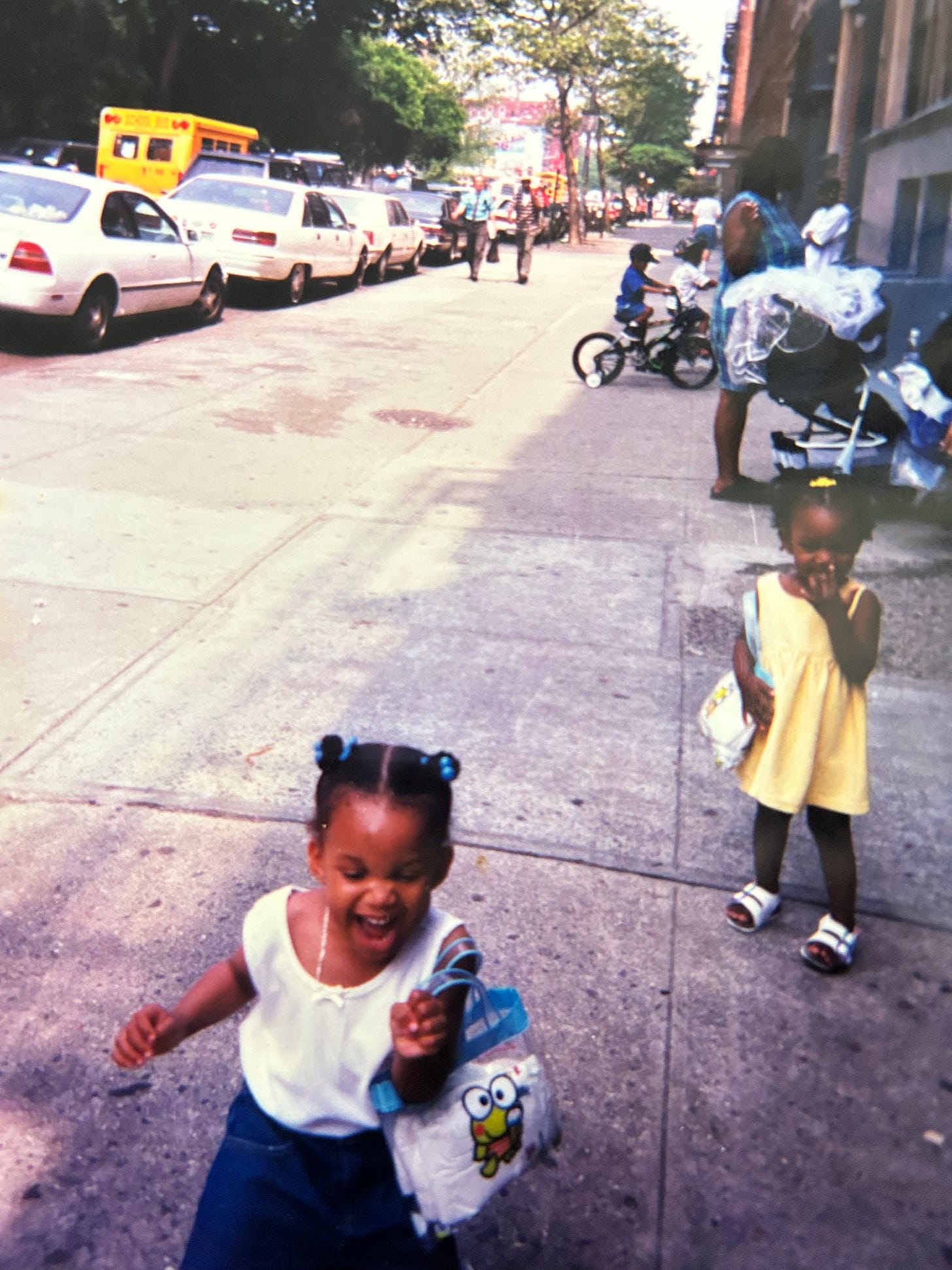 Two little girls on a Brooklyn sidewalk. 
