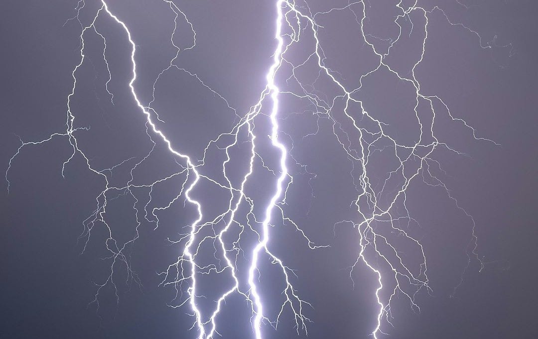 a lightning bolt strikes across a cloudy sky