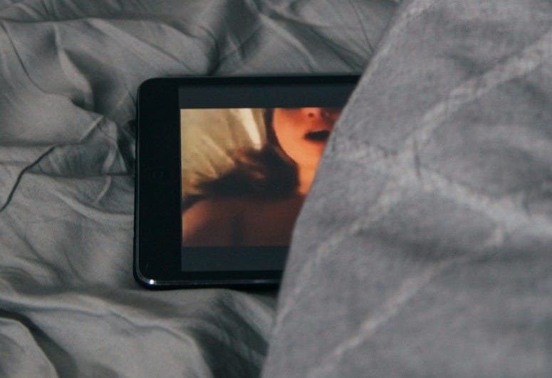 black Android smartphone on gray bed sheet black Android smartphone on gray bed sheet