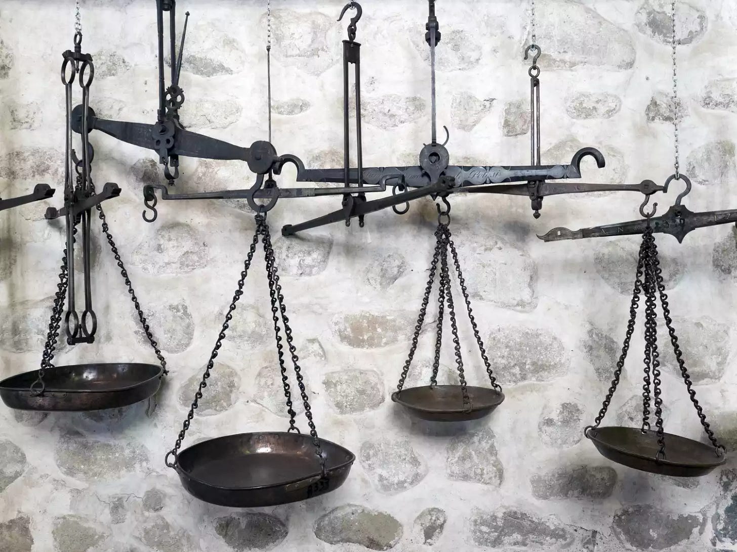 Old scales against a white washed stone wall in Potosi, Bolivia.