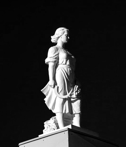 A statue of a woman on top of a building