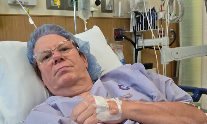 Clara lying in a hospital bed getting ready for surgery