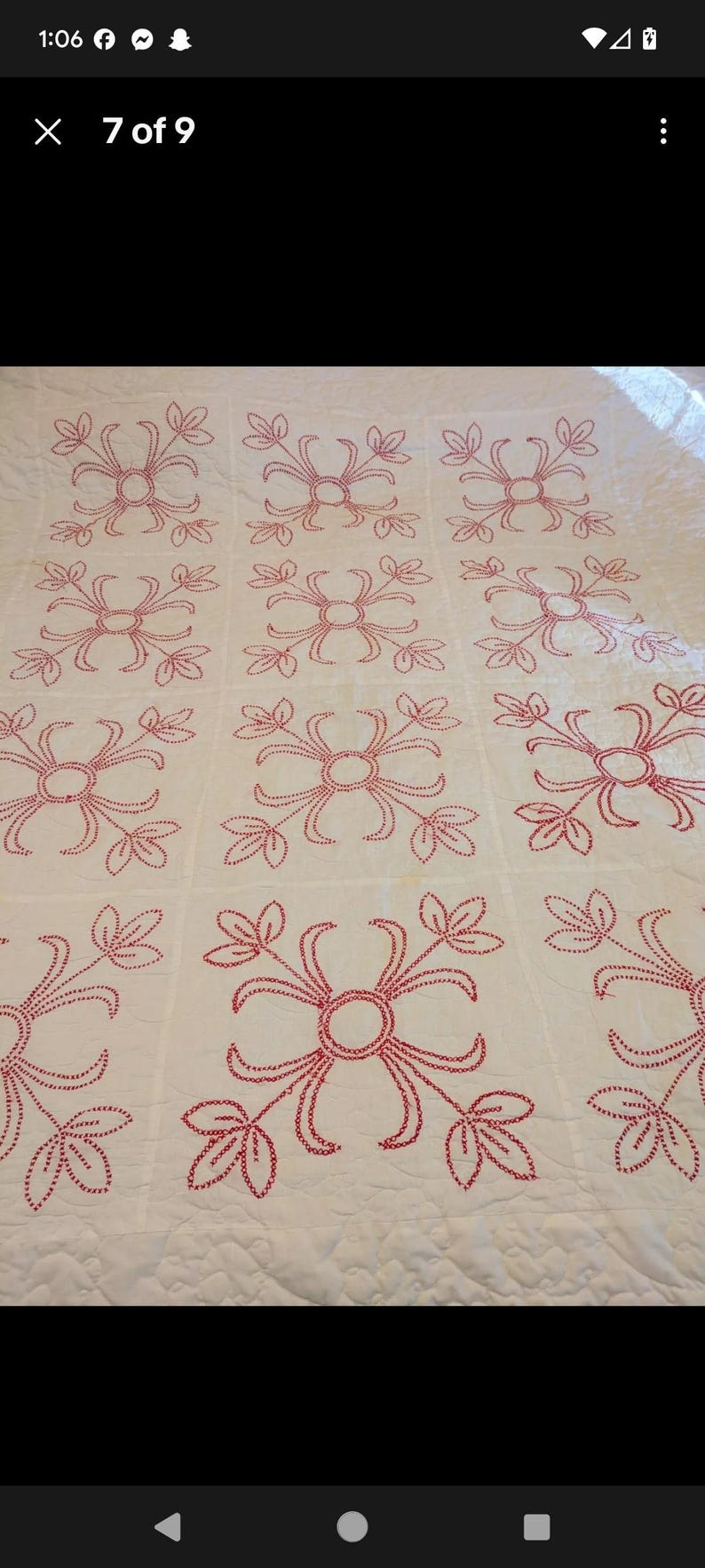 May include: Cream-colored quilt with a repeating pattern of red floral designs. Each design features a central circle with radiating lines and leaf-like shapes, creating a symmetrical pattern across the fabric. May include: Cream-colored quilt with a repeating pattern of red floral designs. Each design features a central circle with radiating lines and leaf-like shapes, creating a symmetrical pattern across the fabric.