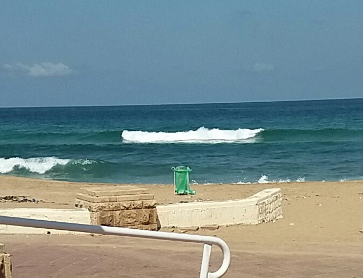 beach at Nahariya with waves, wall, and sand