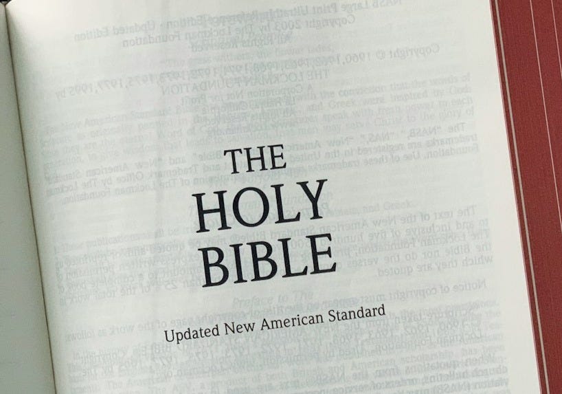 an open bible on a wooden table