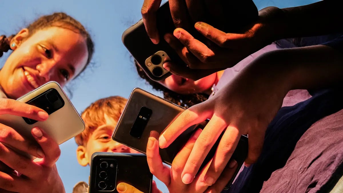 Close-up of teenage friends using mobile phone outdoors. Close-up of teenage friends using mobile phone outdoors.
