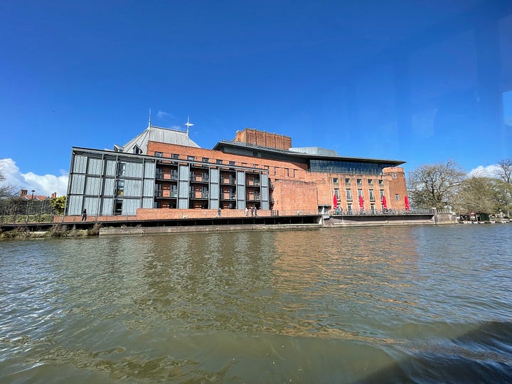 Old Tudor house with wood beams, old windows against a blue sky; swans and ducks on the River Avon; The old public librabry in white and wood Tudor style; The Royal Shakespeare Theatre; The Pen and Parchment pub with sign hanging, windows and flowers