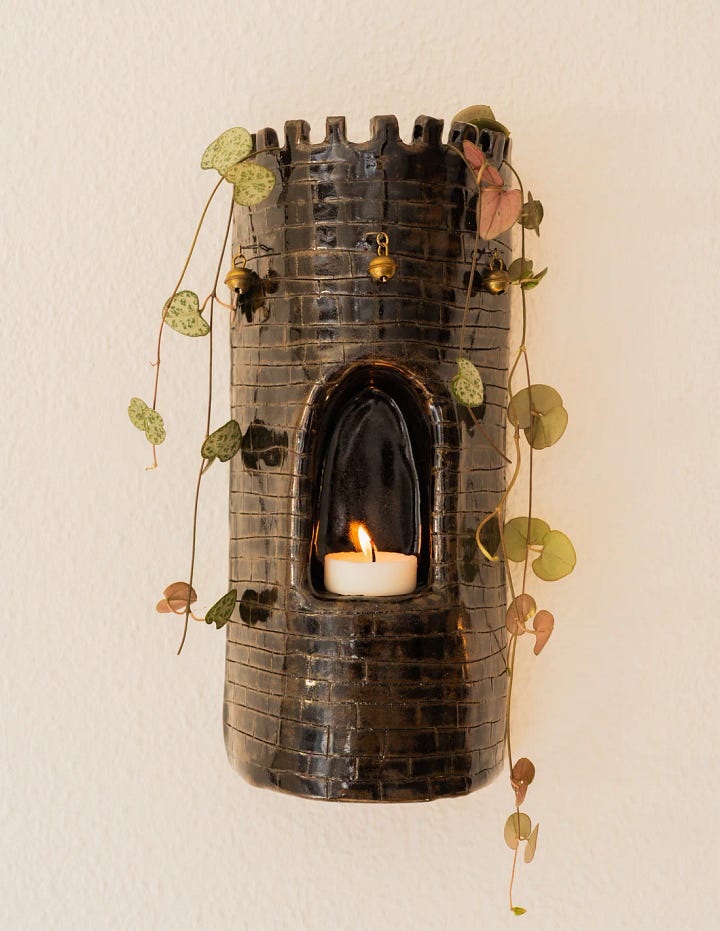 Photo One: a handmade ceramic sconce in the shape of a castle tower. Second photo: a linocut print of flowers and tomatoes.