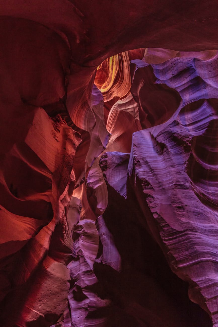 A carved rugged cave whose walls ae red and purple. Light enters it from above, The cave represents the carved heart of Jesus A carved rugged cave whose walls ae red and purple. Light enters it from above, The cave represents the carved heart of Jesus