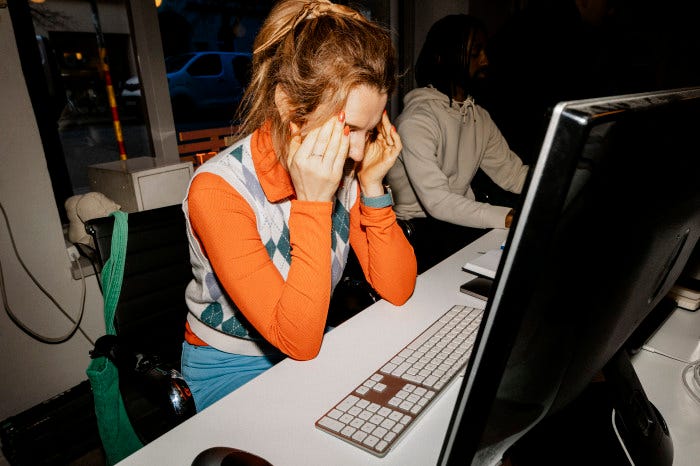 Frustrated female entrepreneur touching her temples while sitting at her desk in the office. Frustrated female entrepreneur touching her temples while sitting at her desk in the office.