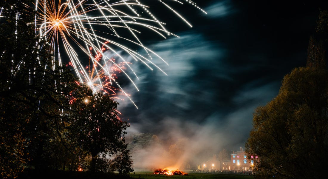 A fireworks scene with a tree, a bonfire, and a colourful house A fireworks scene with a tree, a bonfire, and a colourful house