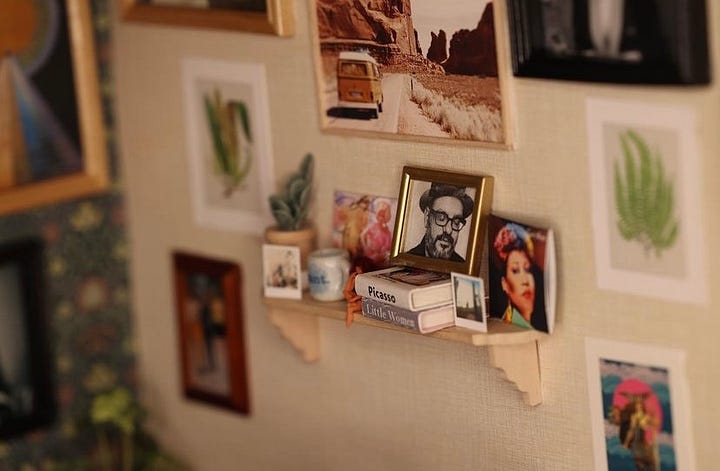 Close up images of the miniature room. Books Amber has written, the "Y: The Last Man" graphic novel, a photo of her husband, a typewriter, and tarot cards can be seen.