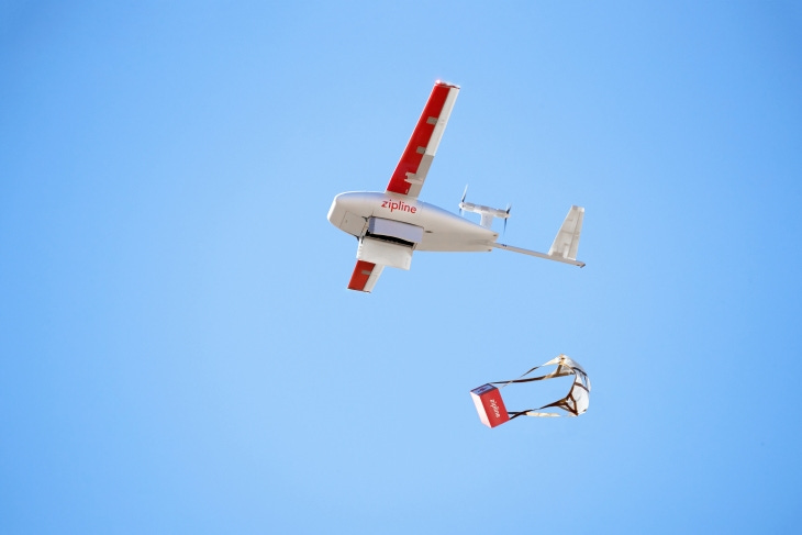 A Zipline drone drops a parachuted package out of the sky