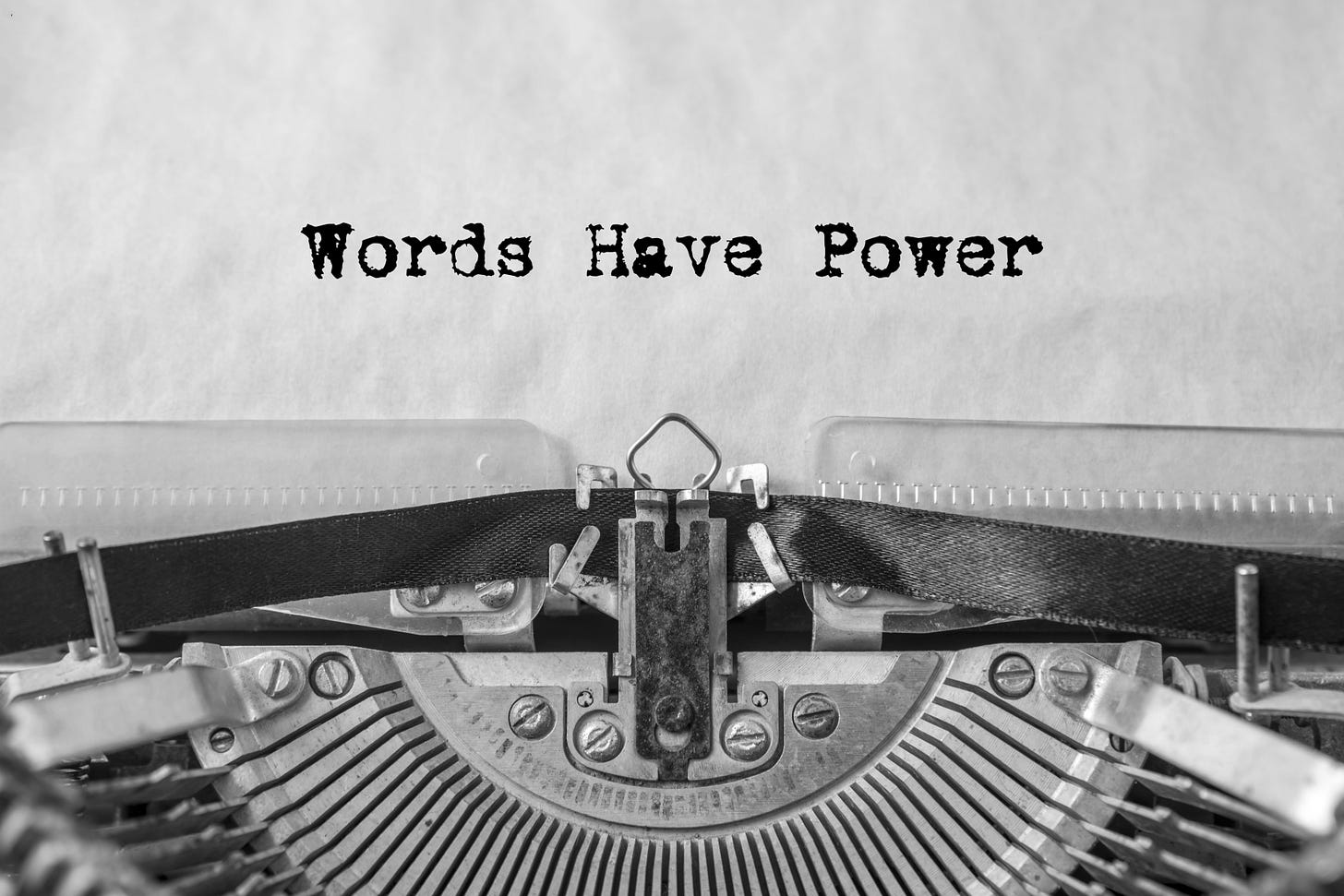 Close up of a typewriter with the words "Words have power" on a piece of paper.