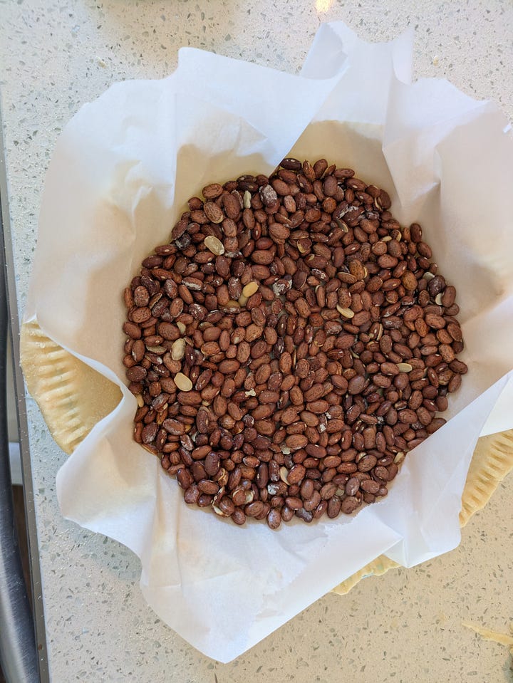 Finished pre-baked pie crust. Ready for initial bake with parchment paper and dried beans.