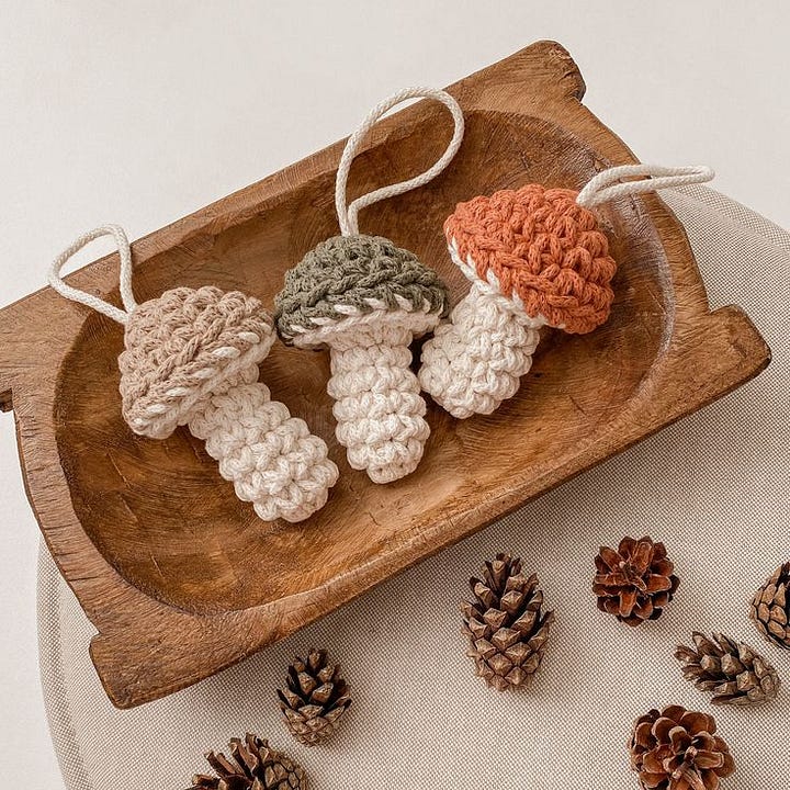A crocheted garland strung with yellow stars and crochet mushrooms attached with a loop as an ornament