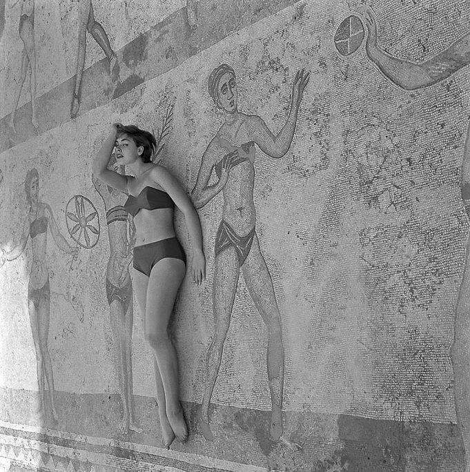 A model lays on the bikini girl mosaic in the villa del casale in Sicily in sicily A model lays on the bikini girl mosaic in the villa del casale in Sicily in sicily
