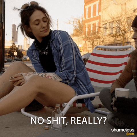 Scene from Showtime's 'Shameless' showing a person in a blue plaid shirt sitting outdoors with the sarcastic caption 'NO SHIT, REALLY?' displayed at the bottom