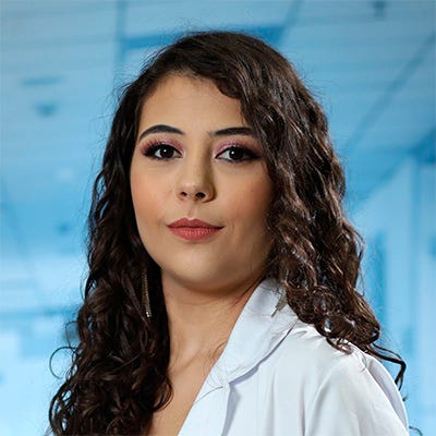 Mulher branca, cabelo cacheado e olhos castanhos vestida de jaleco. Fundo hospitalar. Mulher branca, cabelo cacheado e olhos castanhos vestida de jaleco. Fundo hospitalar.