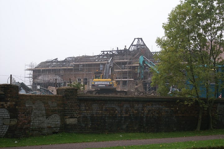 Picture one is black and white and shows two scaffolding-covered bottle shaped kilns reflected in the canal beneath. The second photo shows a more general view across the site with a big yellow digger sitting on top of the rubble.